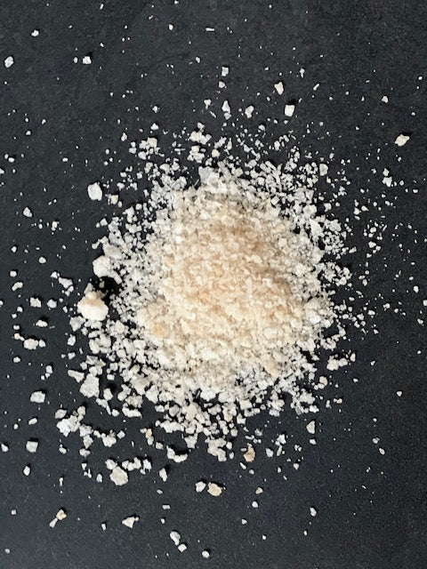 Pile of white salt crystals on a black surface